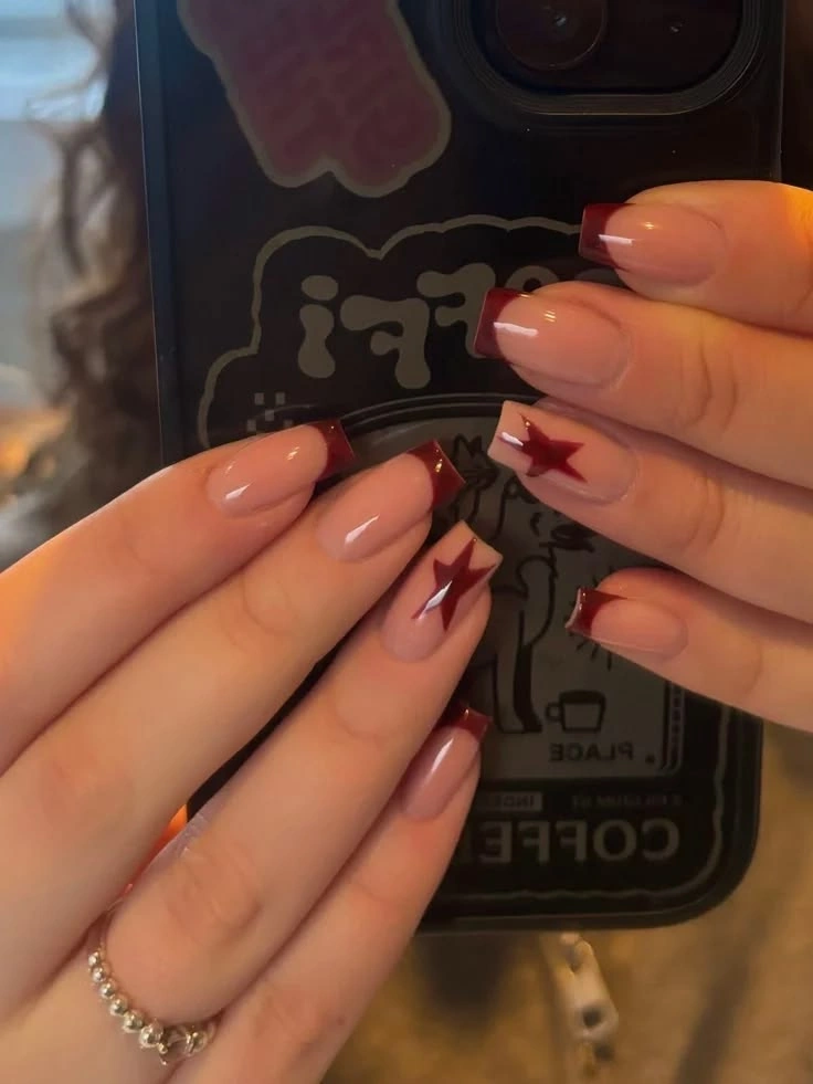Довгий квадрат із темно-бордовими кінчиками та зірками на акцентних нігтях