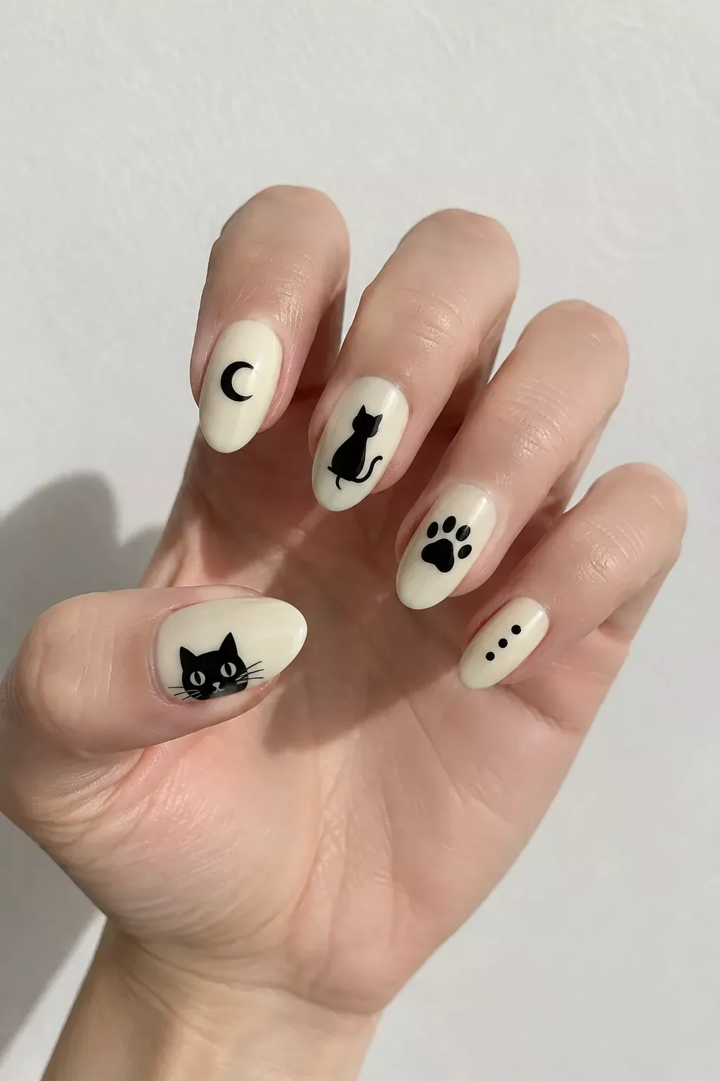 Кот, луна и лапа на молочной основе маникюр с котиком: чёрные силуэты кота, луны и лапки на молочных ногтях миндалевидной формы
